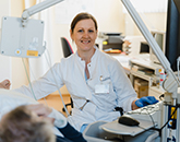 Ärztin untersucht Patientin auf einer Liege